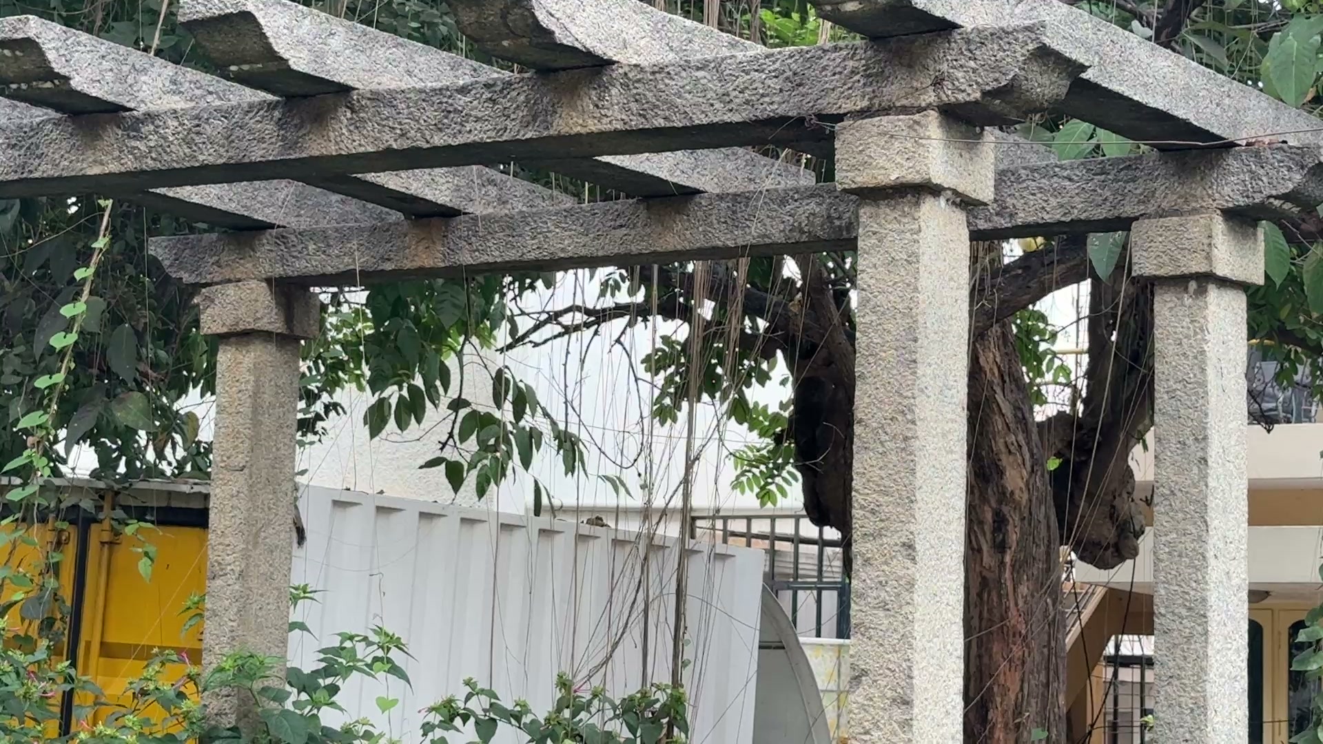 The stone pergola at the entrance threshold.
