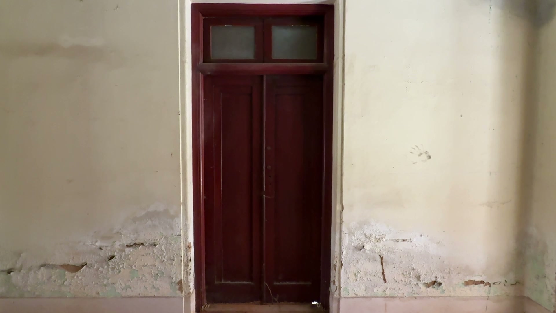 A red-painted Burma teak door, its panels worn smooth by decades of use.